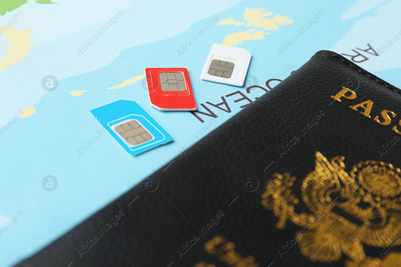 Photo of Passport and SIM cards on world map, closeup