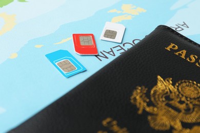 Photo of Passport and SIM cards on world map, closeup