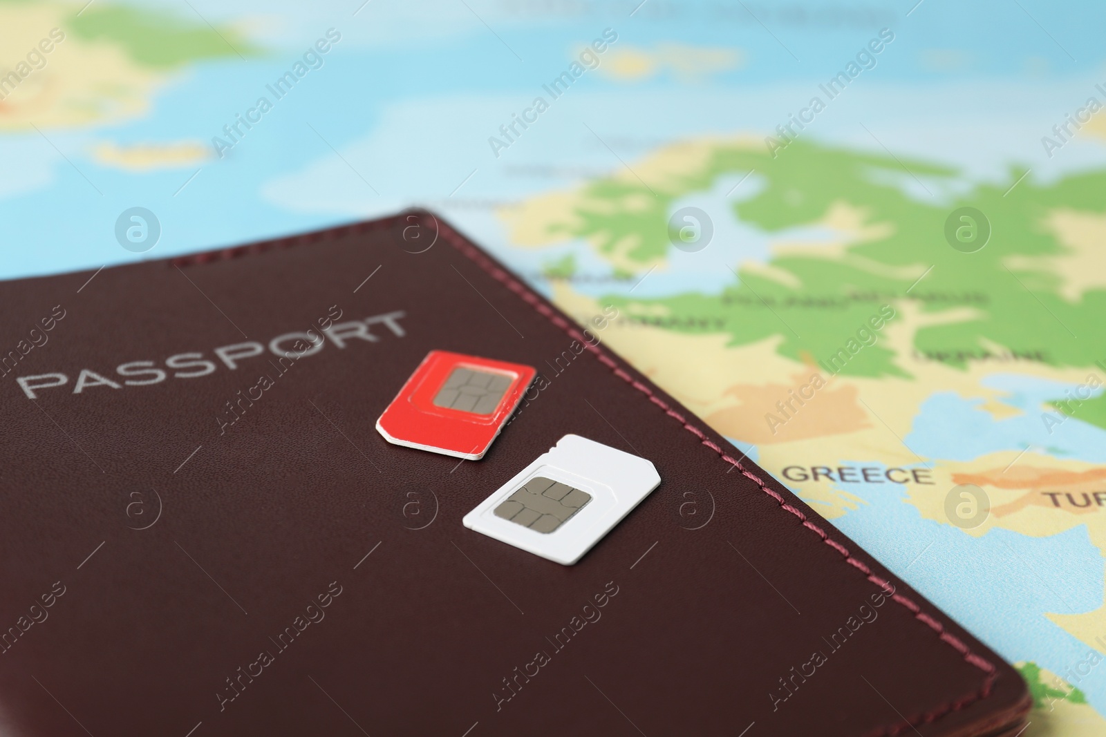 Photo of SIM cards and passport on world map, closeup