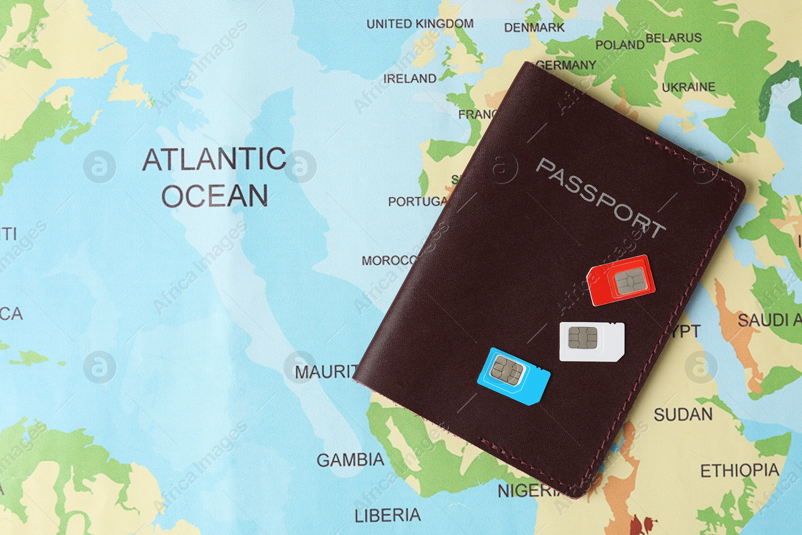 Photo of SIM cards and passport on world map, flat lay