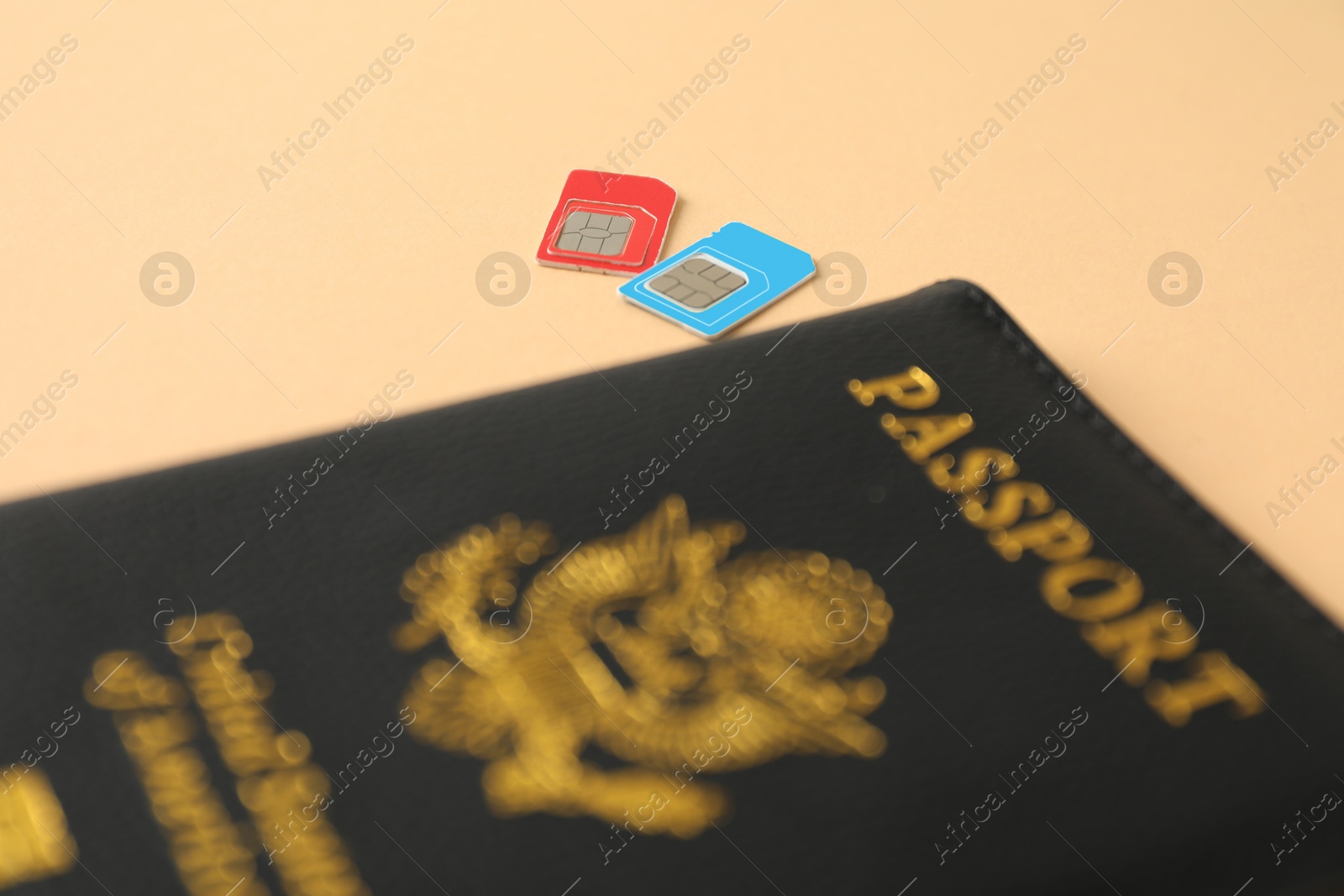 Photo of Modern SIM cards and passport on beige background, closeup