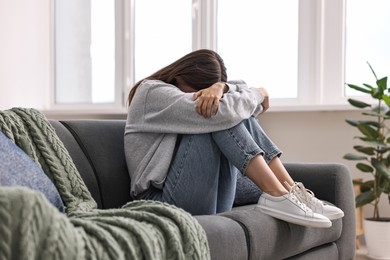 Photo of Loneliness concept. Sad teenage girl on sofa at home