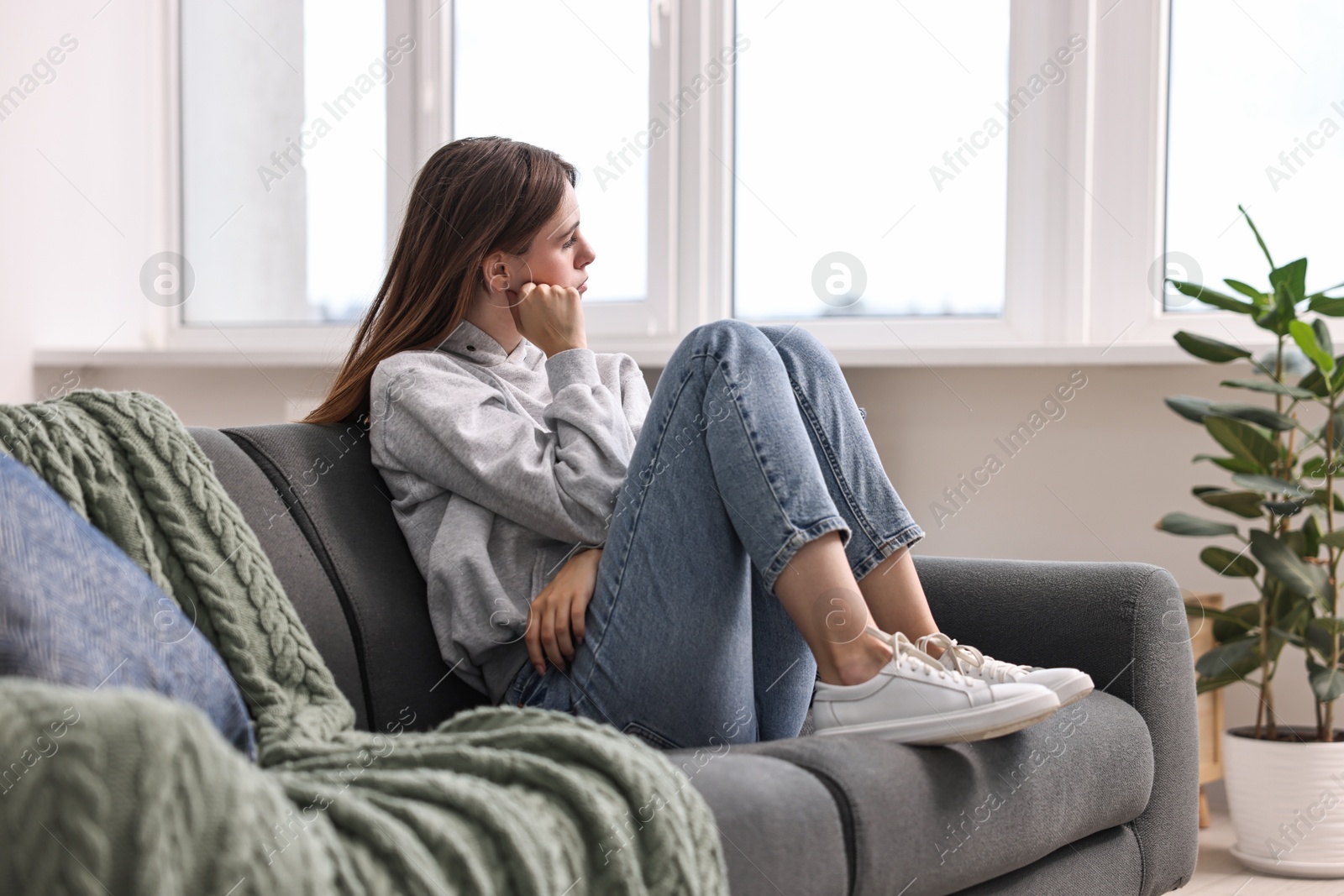 Photo of Loneliness concept. Sad teenage girl on sofa at home