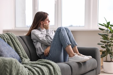 Loneliness concept. Sad teenage girl on sofa at home