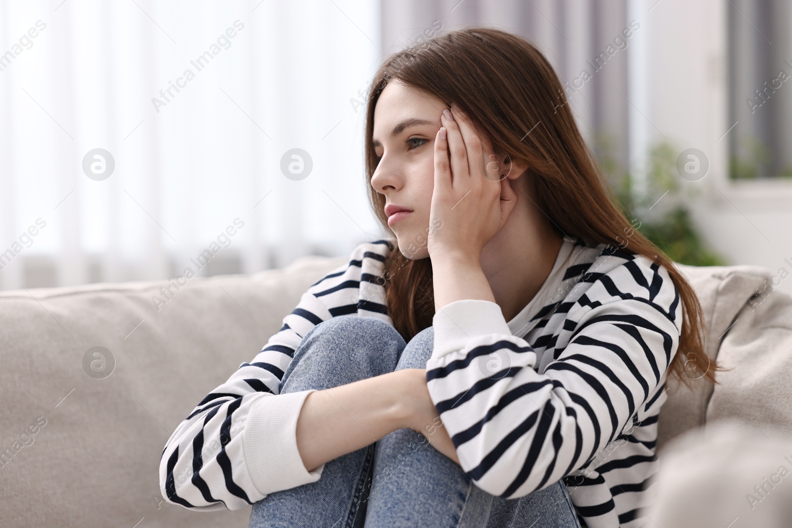 Photo of Loneliness concept. Sad teenage girl on sofa at home