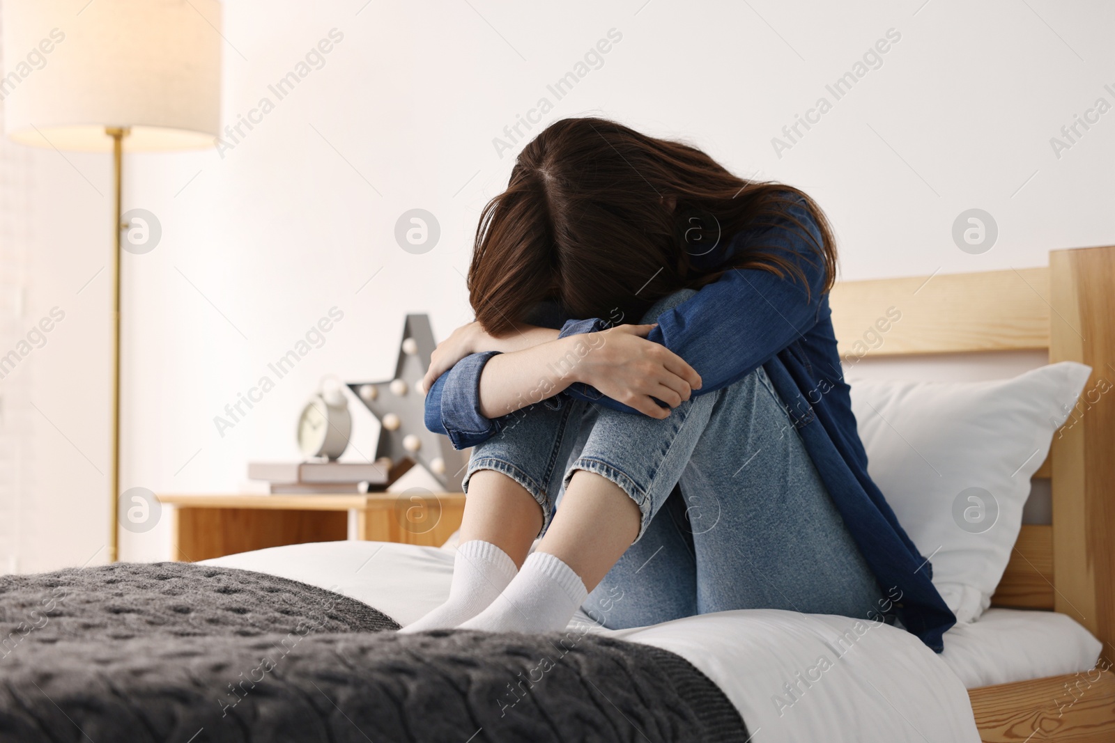 Photo of Loneliness concept. Sad teenage girl on bed at home