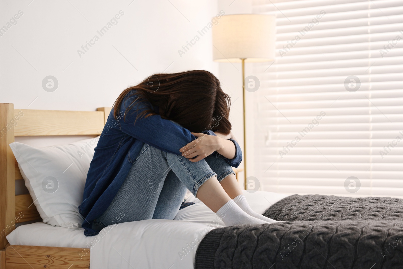 Photo of Loneliness concept. Sad teenage girl on bed at home