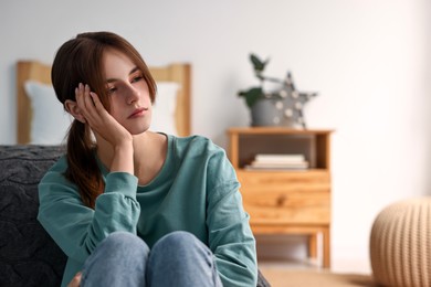 Photo of Loneliness concept. Sad teenage girl at home, space for text