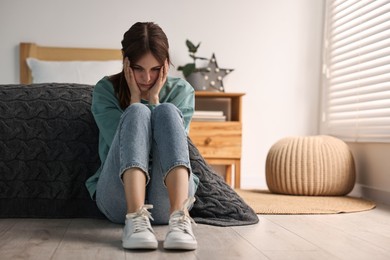 Photo of Loneliness concept. Sad teenage girl on floor at home, space for text