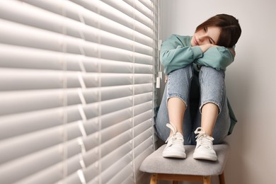 Photo of Loneliness concept. Sad teenage girl near window at home