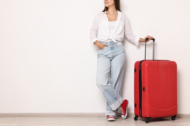 Photo of Woman with suitcase indoors, closeup. Space for text