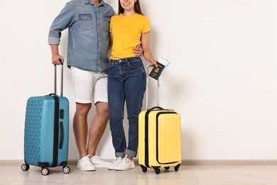 Photo of Couple with suitcases, passport and tickets indoors, closeup. Space for text