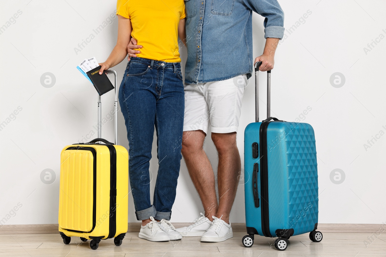 Photo of Couple with suitcases, passport and tickets indoors, closeup