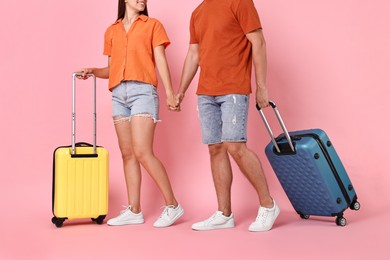 Photo of Woman and man with suitcases on pink background, closeup