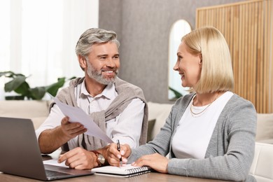 Photo of Couple planning pension budget at table indoors