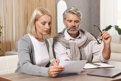 Couple planning pension budget at table indoors