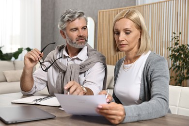 Couple planning pension budget at table indoors