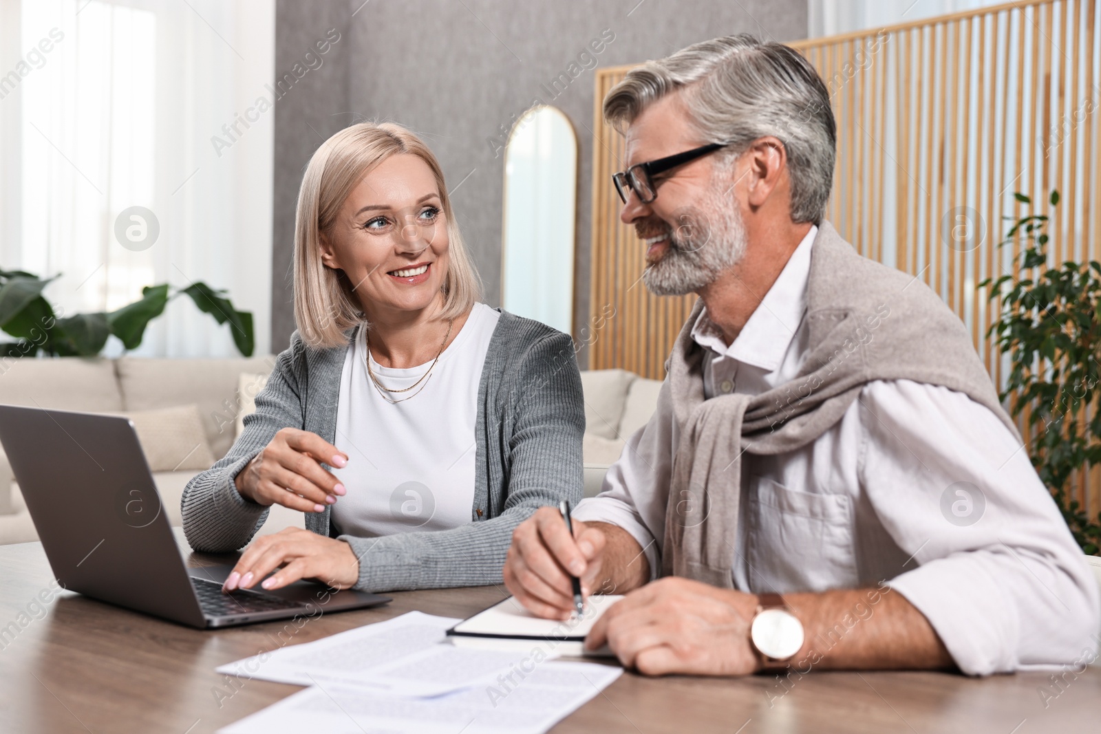 Photo of Couple planning pension budget at table indoors