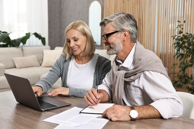 Couple planning pension budget at table indoors