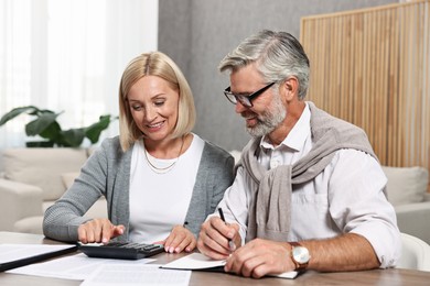 Couple planning pension budget at table indoors