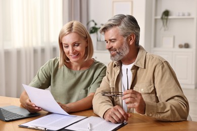 Couple planning pension budget at table indoors