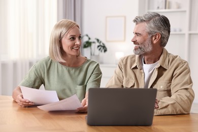 Photo of Couple planning pension budget at table indoors