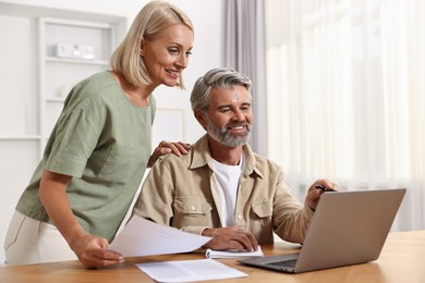 Photo of Couple planning pension budget at table indoors