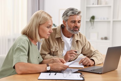 Couple planning pension budget at table indoors