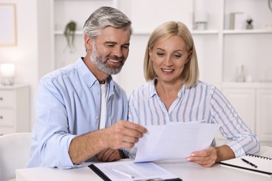 Pension savings. Couple planning budget at table indoors