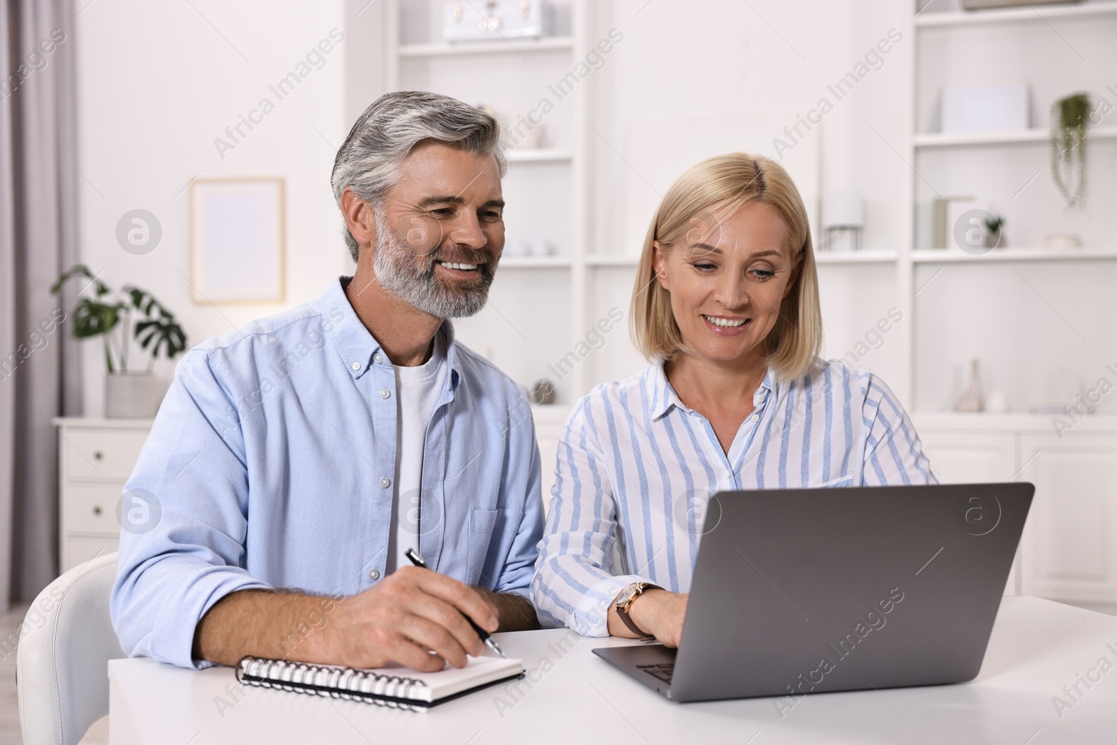 Photo of Pension savings. Couple planning budget at table indoors