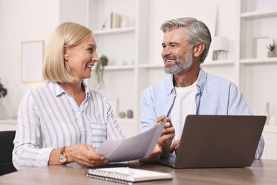 Pension savings. Couple planning budget at table indoors