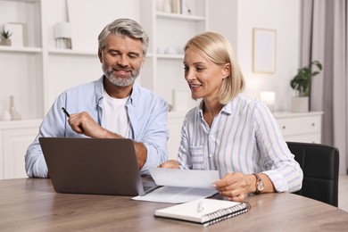 Pension savings. Couple planning budget at table indoors