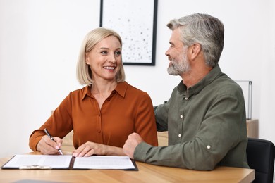 Pension savings. Couple planning budget at table indoors