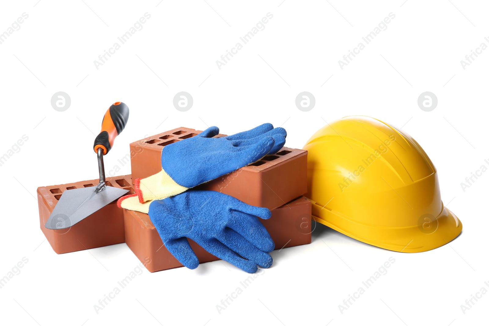 Photo of Red bricks, gloves, hard hat and trowel on white background