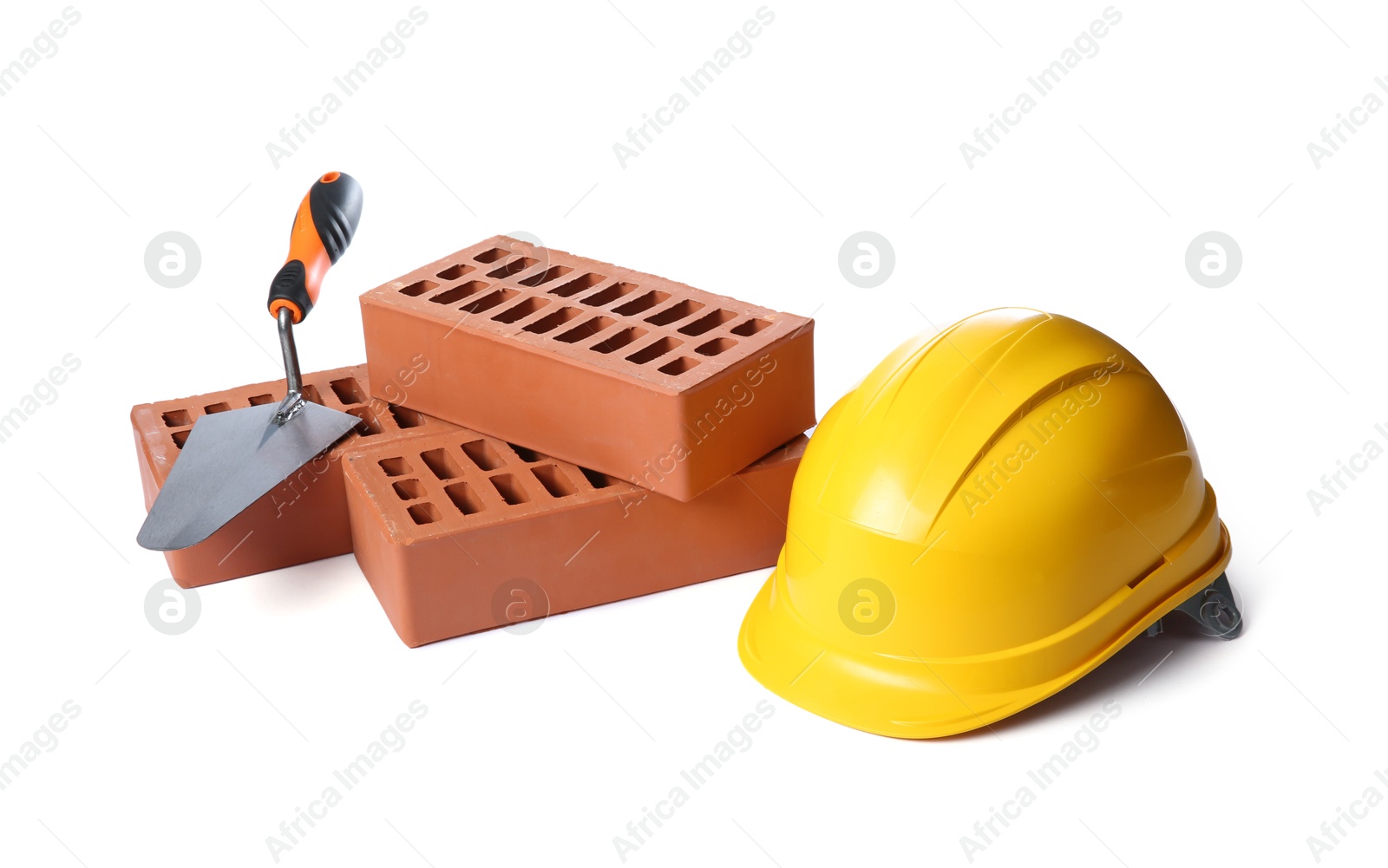 Photo of Red bricks, hard hat and trowel on white background