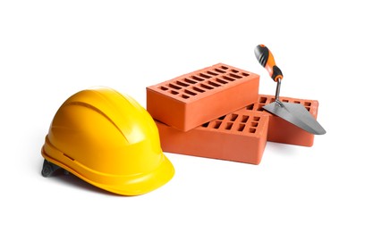 Red bricks, hard hat and trowel on white background