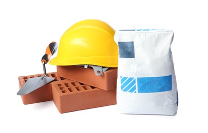 Red bricks, bag of cement, hard hat and trowel on white background