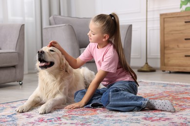 Photo of Girl with her cute Golden Retriever dog on rug at home