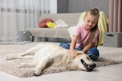 Girl with her cute Golden Retriever dog on rug at home