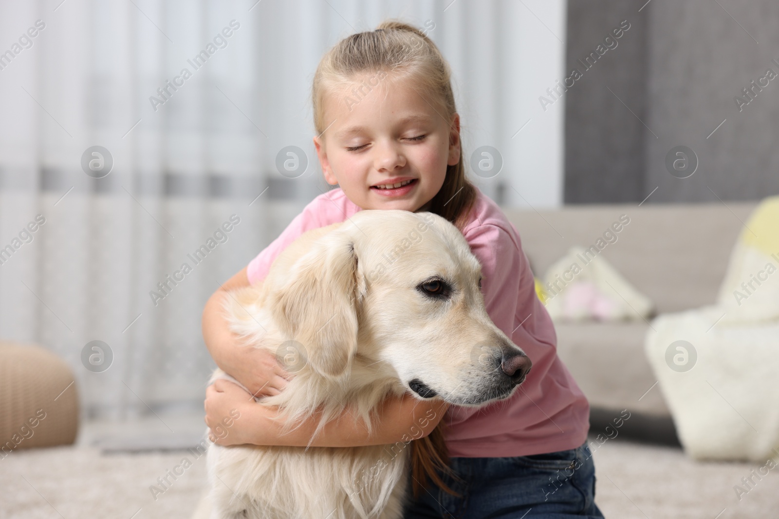 Photo of Girl with her cute Golden Retriever dog at home