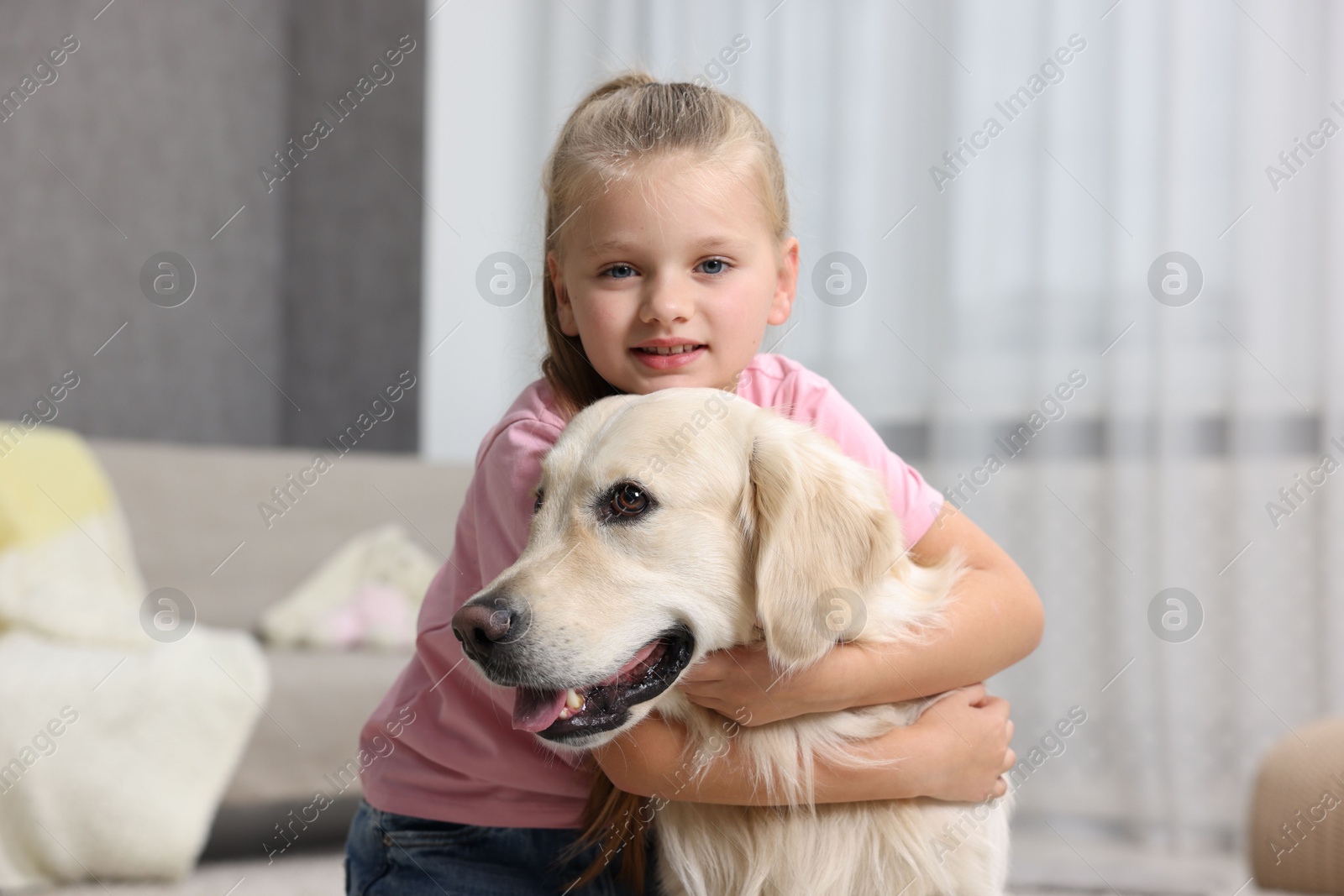 Photo of Girl with her cute Golden Retriever dog at home