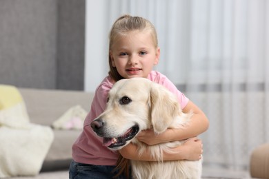 Girl with her cute Golden Retriever dog at home