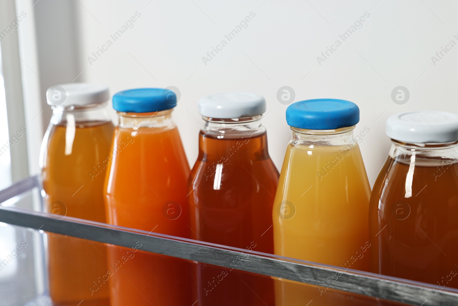 Photo of Many bottles of juice in refrigerator, closeup