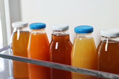 Photo of Many bottles of juice in refrigerator, closeup