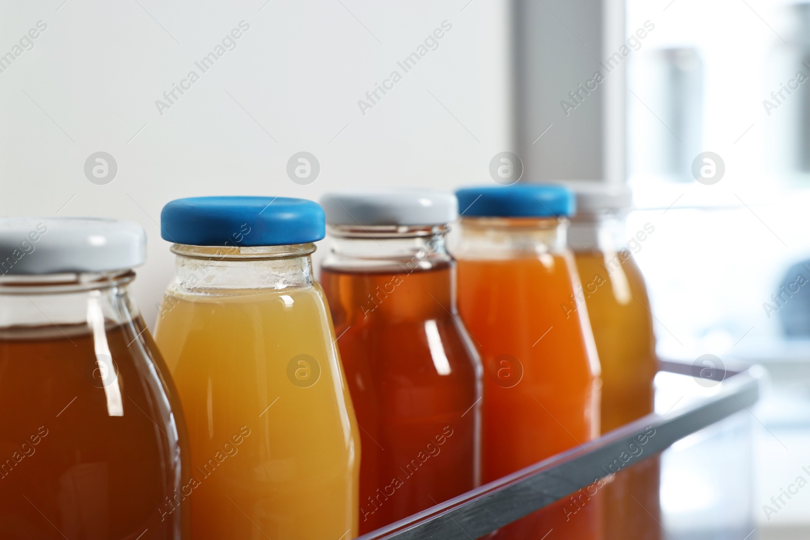 Photo of Many bottles of juice in refrigerator, closeup