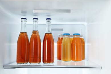 Photo of Many bottles of juice in refrigerator, closeup