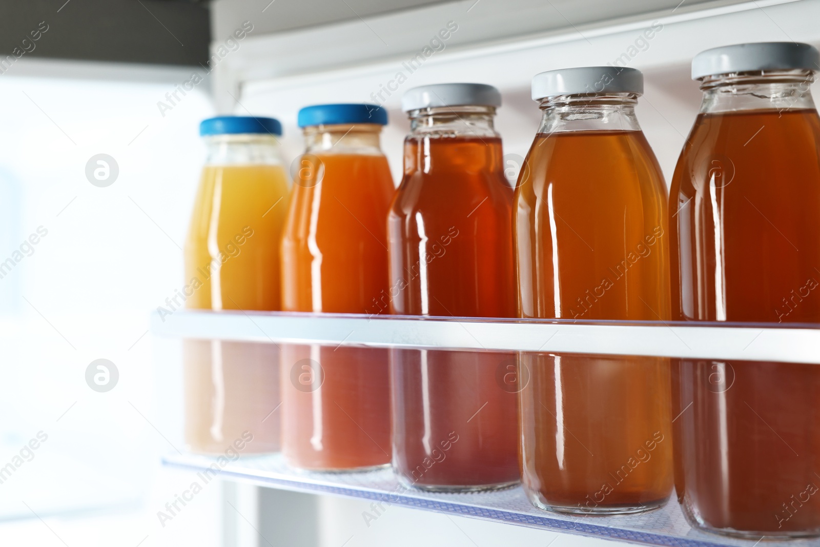 Photo of Many bottles of juice in refrigerator, closeup