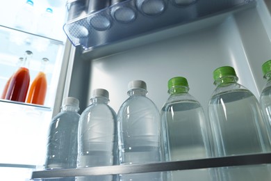 Many bottles of water in refrigerator, low angle view