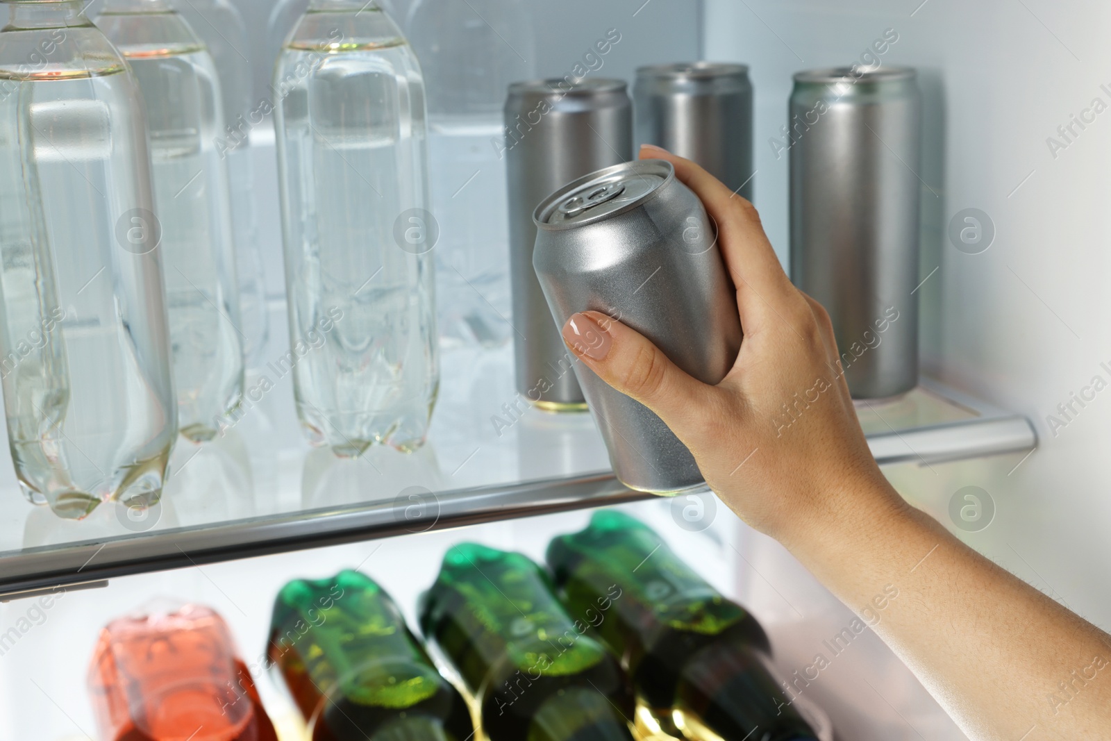 Photo of Woman taking can of beer from refrigerator, closeup