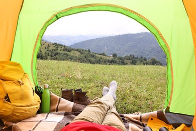 Photo of Woman lying in tent outdoors, closeup view